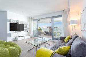 sala de estar con sofá y TV en Janssun Cabopino Luxury Apartment by GHR Rentals, en Marbella