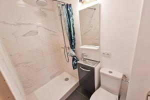 a white bathroom with a shower and a toilet at GregBnb-com - Centre Ancien - T2 Street Art - Wifi in Toulon