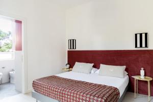 a bedroom with a large bed with a red headboard at Villa delle Palme in Santa Marinella