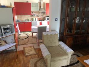 a living room with a couch and a kitchen with red cabinets at House Greda in Bihać