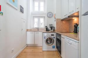 a kitchen with a washing machine and a sink at LV Premier Apartments Baixa- FI in Lisbon