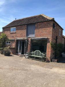 a brick house with a bench in front of it at Impeccable cottage suitable for Three adults in Tockwith