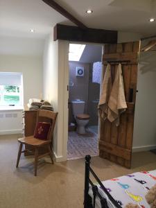 a bedroom with a wooden door leading to a bathroom at Impeccable cottage suitable for Three adults in Tockwith