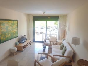 a living room with a couch and chairs and a television at Beautiful apartment 75m2 with view at the beach, pool, parking in Roses