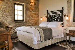a bedroom with a large bed in a brick wall at Polismata - Private Residences in Kardamyli