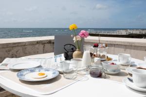a white table with eggs on it with the ocean at Villa delle Palme in Santa Marinella