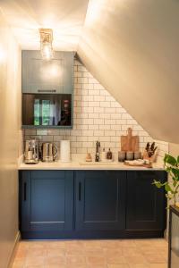 a kitchen with blue cabinets and a sink at Beautiful Luxury Property in the Surrey Hills in Cranleigh