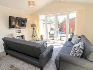 ein Wohnzimmer mit 2 Sofas und einem TV in der Unterkunft Eden Lodge - Sherwood 21 in Carnforth