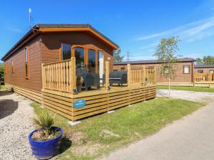 eine große Holzhütte mit einer großen Terrasse in der Unterkunft Eden Lodge - Sherwood 21 in Carnforth