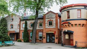 ein Backsteingebäude mit einem Baum davor in der Unterkunft Aleksandri Hotel in Tartu