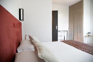 a bedroom with a white bed and a red headboard at Villa delle Palme in Santa Marinella