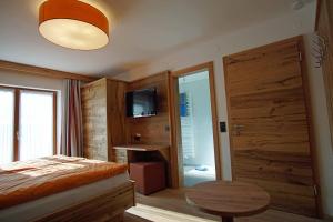 1 dormitorio con cama, mesa y TV en Haus Zauner, en Reit im Winkl