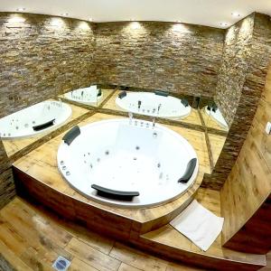 a large bath room with three sinks and a tub at Canti apartments in Novi Sad