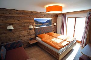 a bedroom with a bed with a wooden wall at Haus Zauner in Reit im Winkl