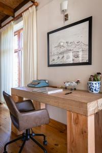 a wooden desk with a chair in a room at Kinghorns Gardens in Cape Town