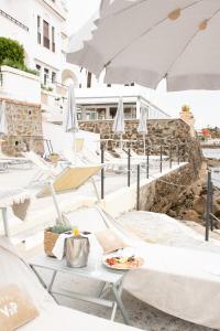 a restaurant with white chairs and tables and umbrellas at Villa delle Palme in Santa Marinella