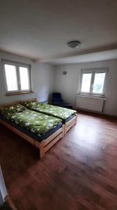 1 dormitorio con 1 cama grande en una habitación con ventanas en Dům u lesa - Nové Hamry, en Nové Hamry