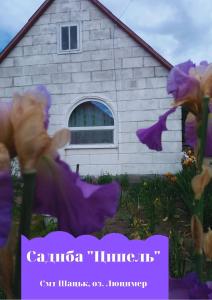 ein Haus mit lila Blumen davor in der Unterkunft Ципель 1 in Szack