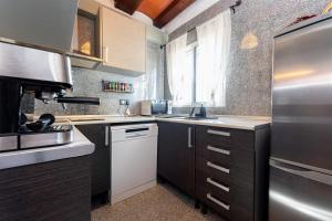 a kitchen with a stainless steel refrigerator and a sink at Hauzify I Mas Blau in L'Ametlla de Mar