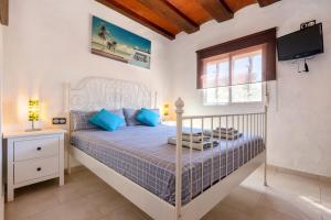 Un dormitorio con una cama con almohadas azules y una ventana en Hauzify I Mas Blau, en L'Ametlla de Mar