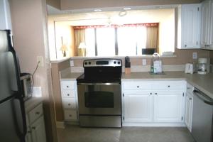 a kitchen with a stove and white cabinets at Club Regency at Regency Towers in Myrtle Beach