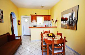 a kitchen and dining room with a table and chairs at theophilos blue cozy apartments in Agios Georgios Pagon