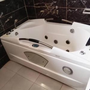 a white bath tub sitting in a bathroom at executive 4bedrooms house in Lagos Nigeria in Lekki