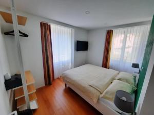 um quarto com uma cama, uma escada e janelas em B&B Cà Nosa em Gordevio