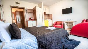 a bedroom with a bed and a red chair at Apartments Passage in Vrnjačka Banja