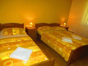 2 łóżka w małym pokoju z żółtą pościelą w obiekcie Apartment Przina 856-2 w mieście Lumbarda