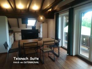 a dining room with a table and chairs and windows at Haus am Osterbrünnl in Ruhmannsfelden