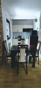 Apartman Spirit of Vlašić في فلاسيتش: غرفة طعام مع طاولة وكراسي ومطبخ