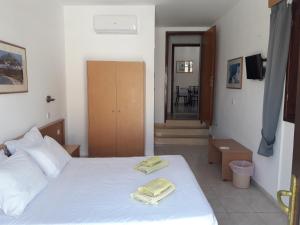 a bedroom with a white bed with two towels on it at PHILIPPOS STUDIOS & APT in Líndos