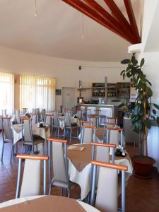 a room with tables and chairs and a kitchen at Motel Sora in Sovata