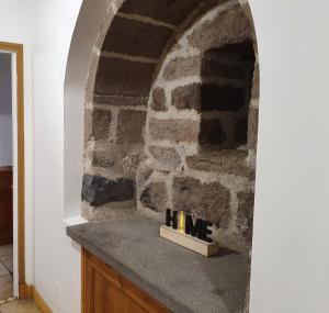 a room with a stone wall with a fireplace at gite du cresponnet in Murat