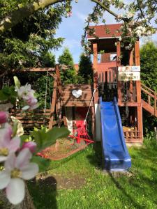 a playground with a blue slide in a yard at Jodła i Modrzew in Jelenia Góra