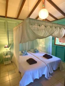 a bedroom with a bed with a canopy at Villa Nature caraïbe lodge, vue mer, piscine privée in Deshaies