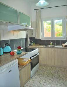a kitchen with a sink and a stove top oven at Holiday House Angelos C on Agios Gordios Beach in Agios Gordios