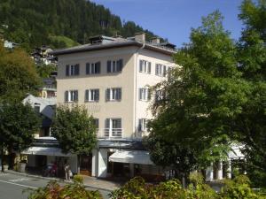duży biały budynek z drzewami przed nim w obiekcie Appartements Steiner - SKI IN - SKI OUT w mieście Zell am See
