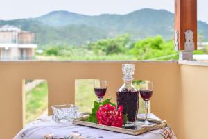a table with two wine glasses and a bottle of wine at House Ilias in Sarti