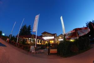 a restaurant with an umbrella on a street at night at Willa Słoneczna in Okuninka