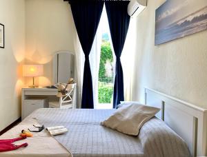 a bedroom with a bed with a window and a desk at Hotel Baia di Levanto in Levanto