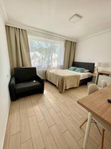 sypialnia z łóżkiem, krzesłem i oknem w obiekcie Pokoje Gościnne i Apartamenty Ula w mieście Ustronie Morskie