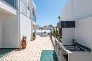 einen Balkon eines Hauses mit einem Waschbecken und einer Theke in der Unterkunft Riad Matias Galé - Luxury Villa with private pool, AC, free wifi, 5 min from the beach in Guia