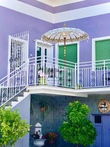 ein lila Haus mit einer Treppe und einem Regenschirm in der Unterkunft Cortile Gancia - Sweet House in Narzole