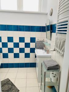 a bathroom with a blue and white tiled wall at Happy Apartments in Poznań