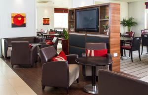 a waiting room with chairs and a flat screen tv at Holiday Inn Express London - Dartford, an IHG Hotel in Dartford