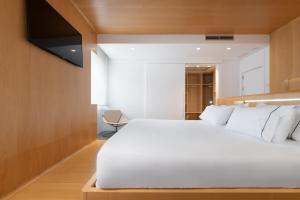 a bedroom with a large white bed and wooden walls at Eurostars Marqués de Vallejo in Logroño
