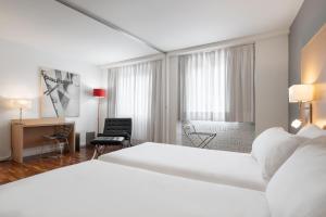 a hotel room with a large bed and a desk at Eurostars Marqués de Vallejo in Logroño