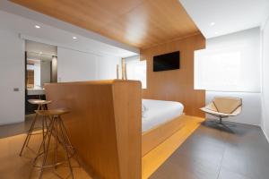 a small bedroom with a bed and a chair at Eurostars Marqués de Vallejo in Logroño